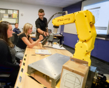 High school students learning FANUC industrial robot programming